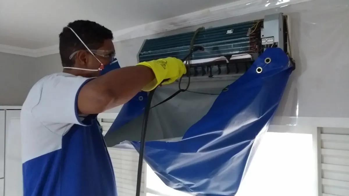 Técnico da Hard Limp higienizando ar condicionado split com bolsa coletora